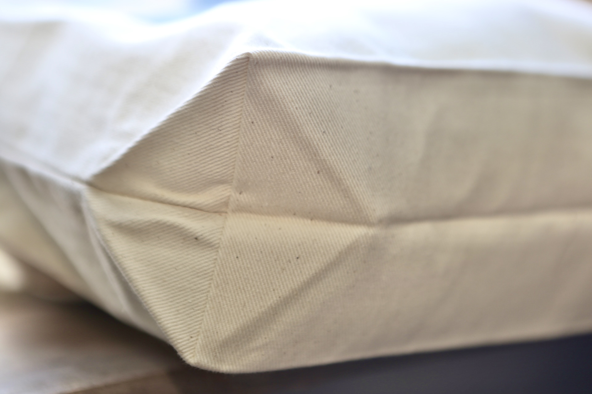 Close detail of the tote's broad bottom gusset and cotton twill texture