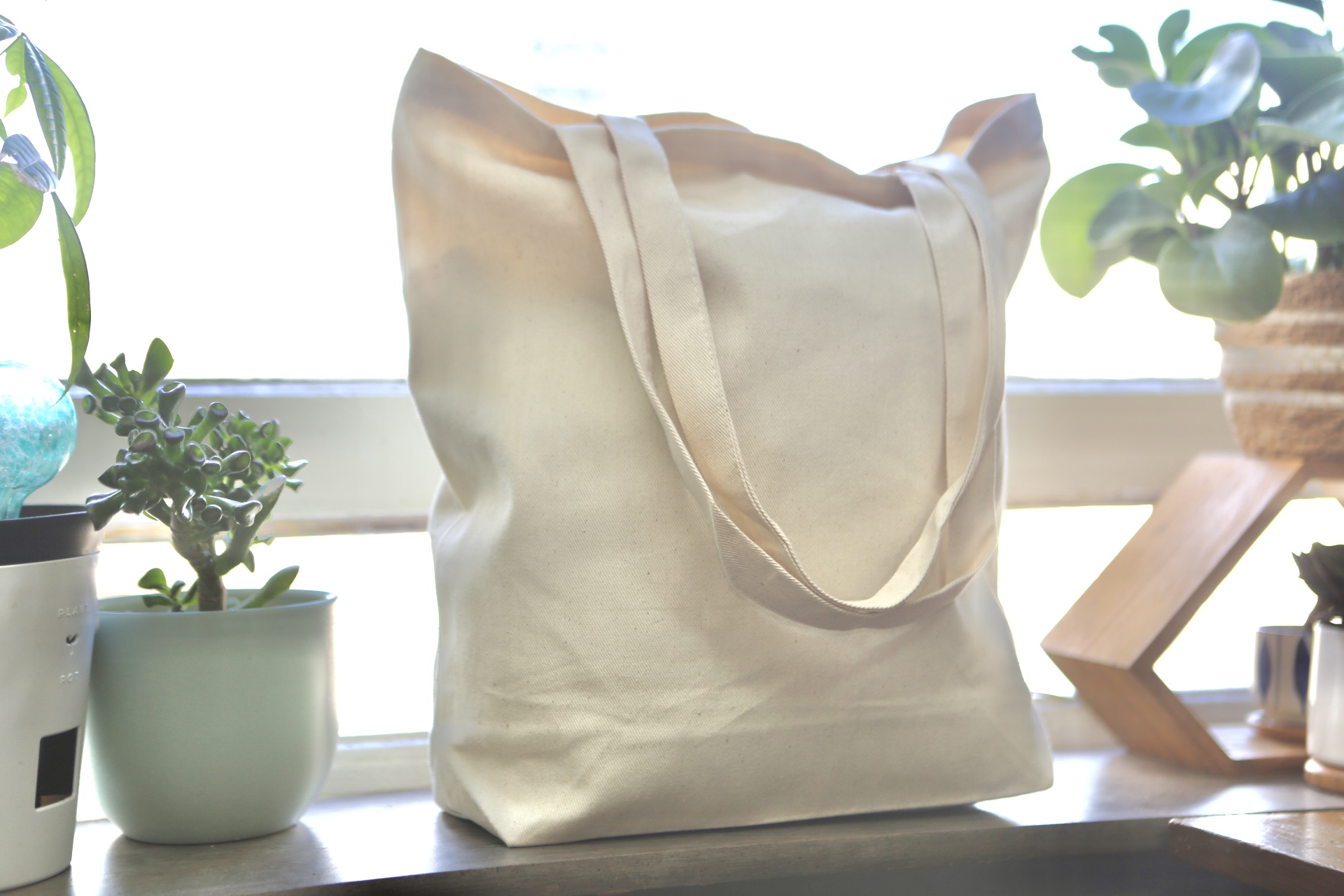 Natural cotton tote standing upright with long shoulder handles